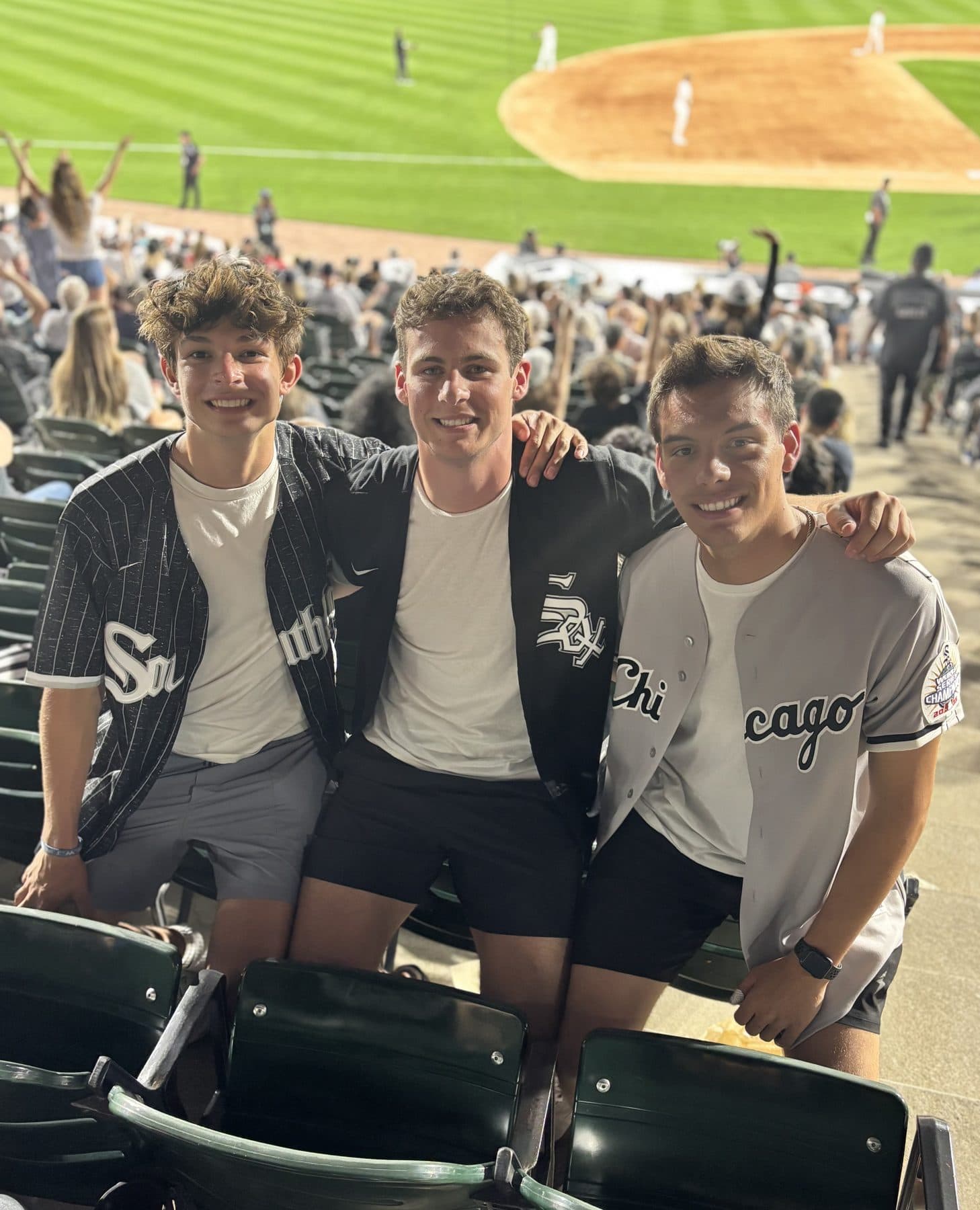 Jeffrey and two friends in jerseys at a Chicago White Sox game