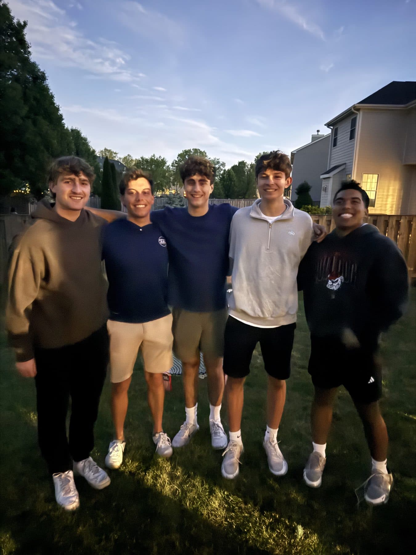 Jeffrey and four friends in a backyard at dusk