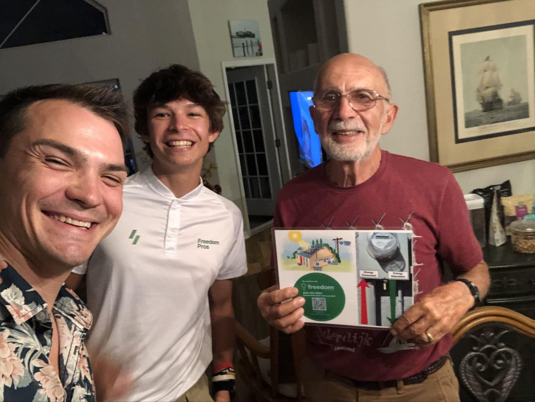 Jeffrey with his sales partner and a homeowner holding a solar information packet