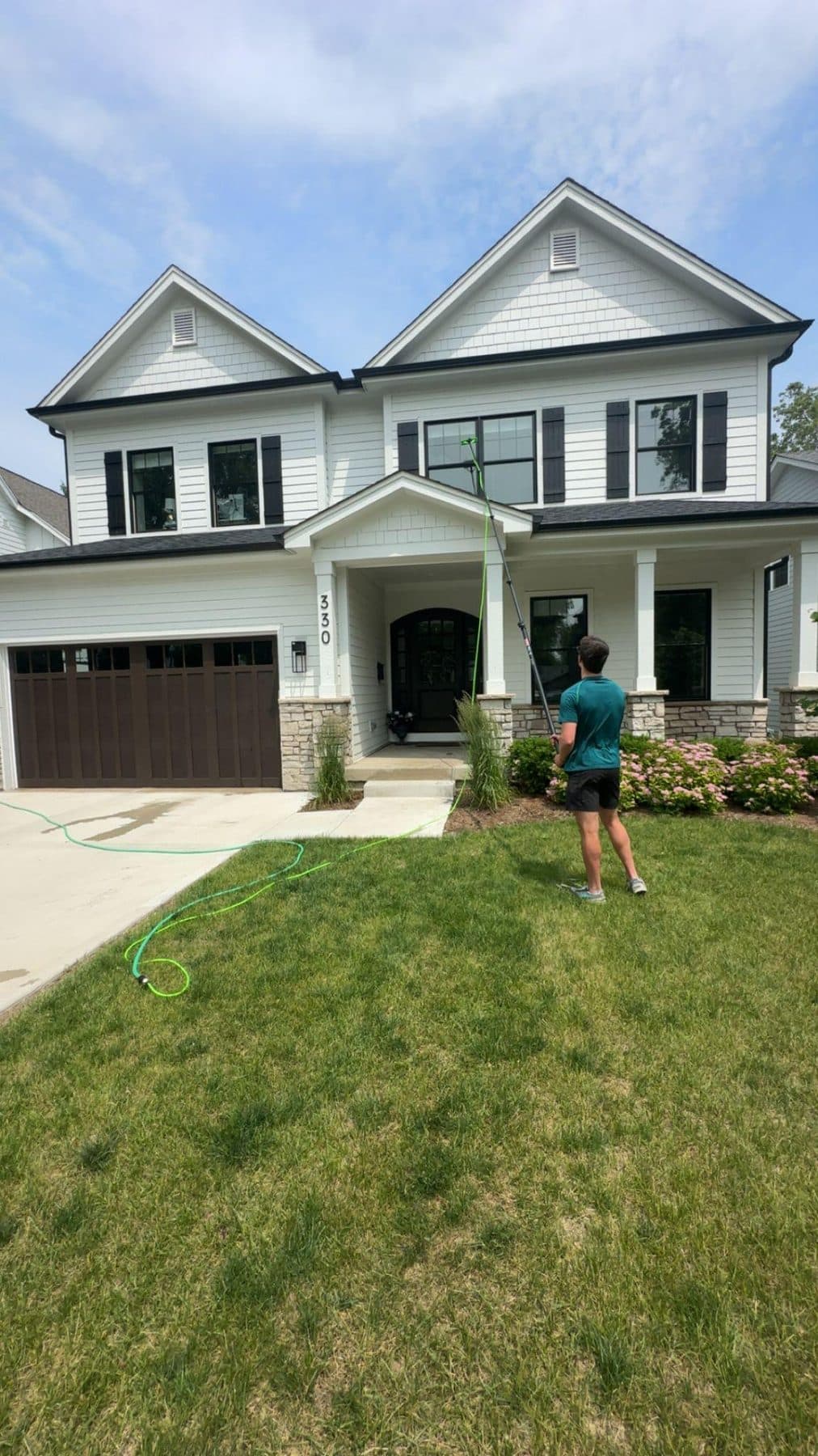 Working the front elevation of a two-storey house with the reach pole extended