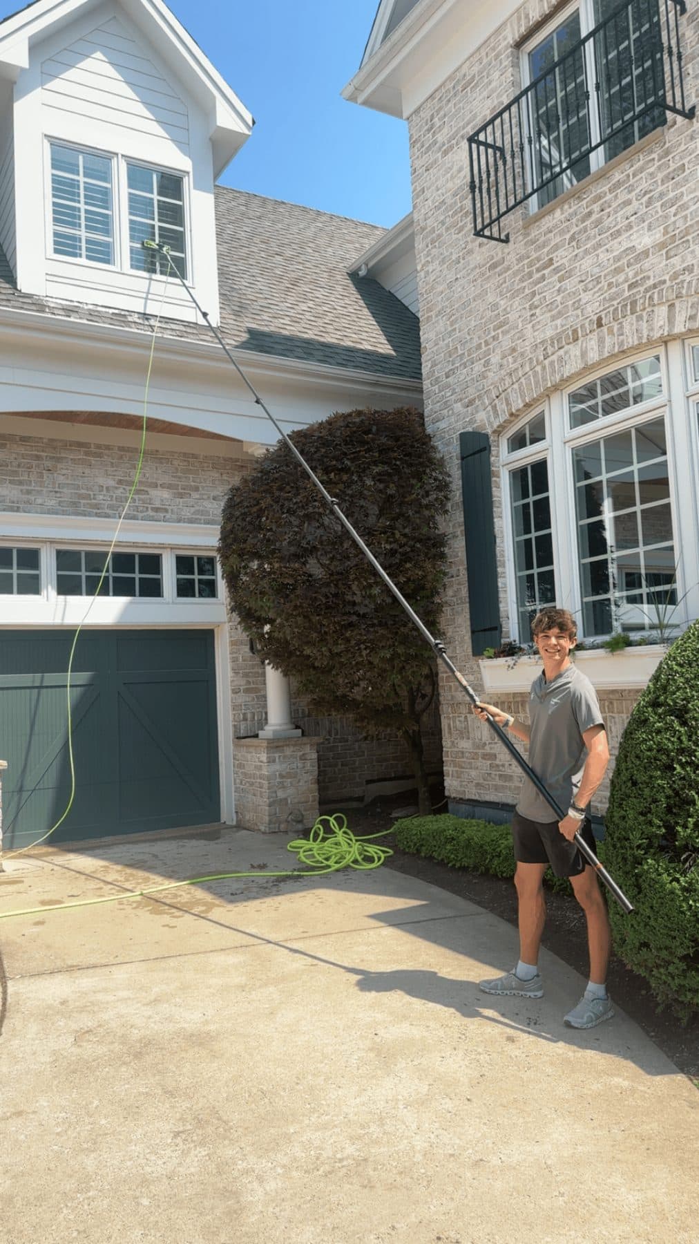 Jeffrey cleaning second-storey windows with a water-fed reach pole